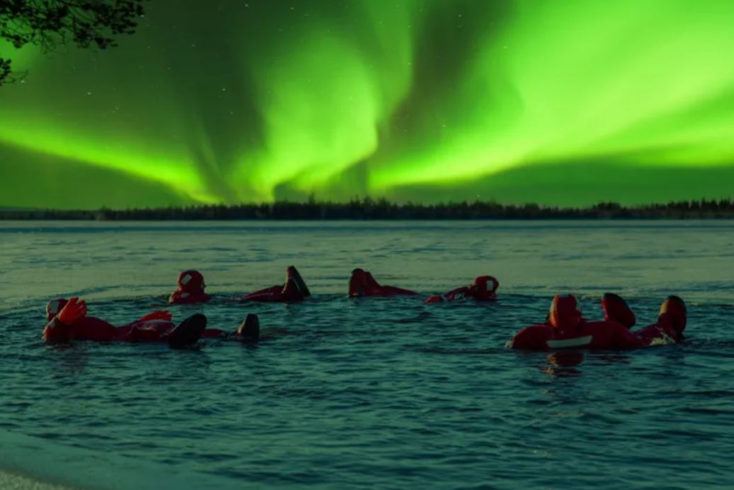 Actividades unicas que hacer en Laponia - bañarse en lago helado con auroras